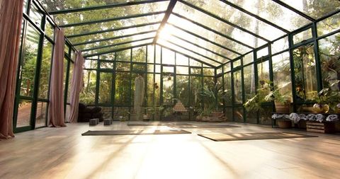 Sunlit Glass Enclosed Yoga Studio with Natural Surroundings