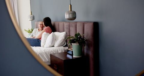 Mother and Daughter Bonding Together on Bed in Reflective Moment