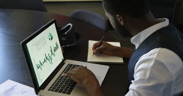 Businessman Working on Financial Report with Laptop and Notebook - Download Free Stock Images Pikwizard.com