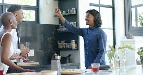 Group celebrating real estate closing in modern kitchen holding keys and toasting