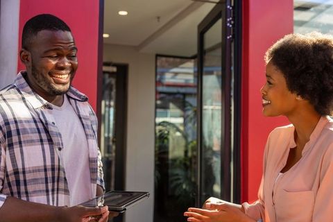 Colleagues Communicating at Modern Entrance with Tablet