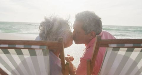 Senior Couple Enjoying Sunset Kiss on Beach Holiday