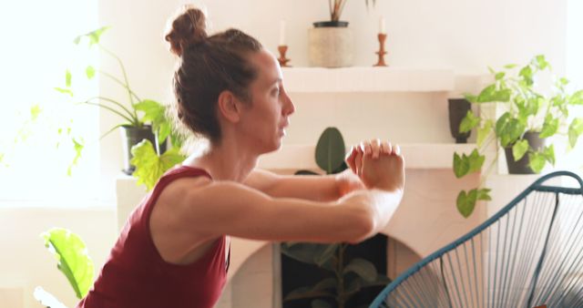 Woman Dressed In Red Exercising In Bright Living Room With Plants - Download Free Stock Images Pikwizard.com