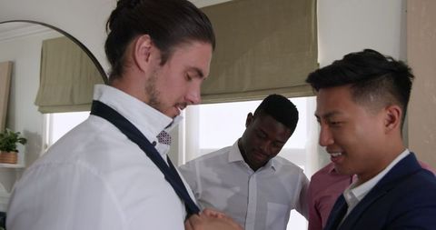 Groom preparing with friends on wedding day
