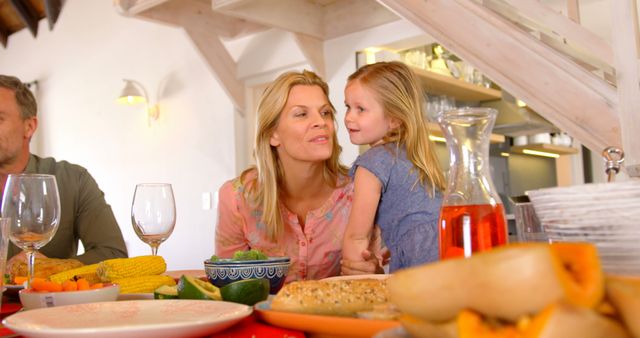 Mother and daughter sharing moment at dinner table - Download Free Stock Images Pikwizard.com