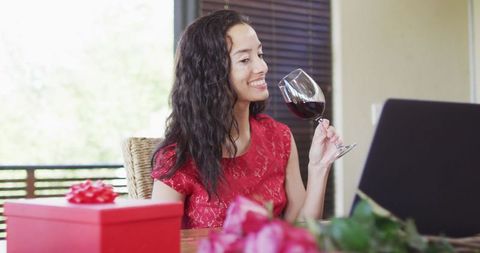 Woman enjoys online wine toast for romantic valentine's celebration