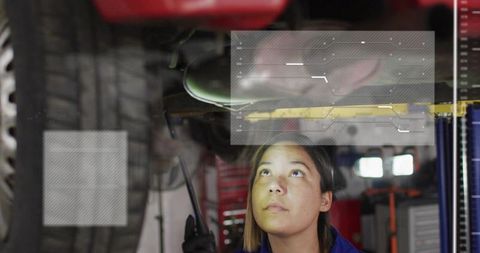 Automotive Technician Inspecting Vehicle Underside on Lift with Augmented Reality HUD