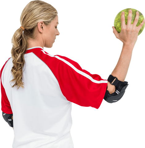 Female athlete is standing, wearing a red and white sports jersey, holding a bright green ball. Image displays rear view emphasizing game focus and determination. Suitable for use in sports articles, promotional material or marketing campaigns targeting athletic lifestyles and teamwork themes.
