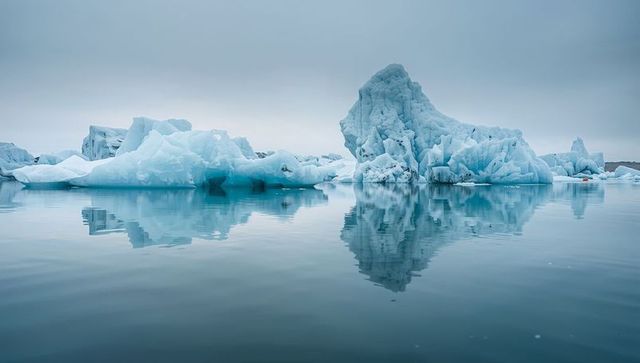 Floating jagged iceberg reflecting on calm polar lagoon, serene arctic glacier landscape