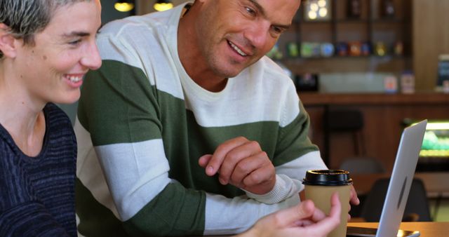 Coworkers Discussing Project Over Laptop in Coffee Shop - Download Free Stock Images Pikwizard.com