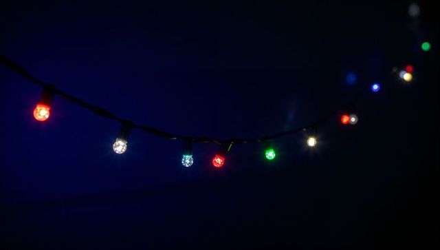Glowing led string lights casting colorful night bokeh, creating festive backyard ambiance