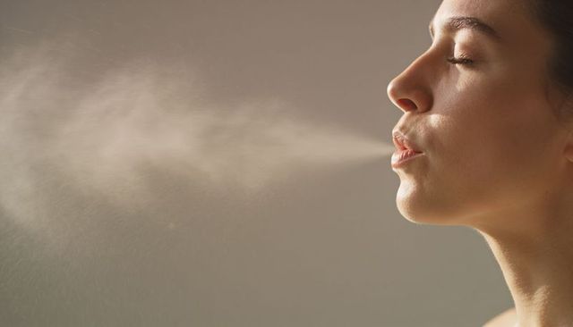 Closeup profile woman exhaling fine mist breath haze for wellness and respiratory concept