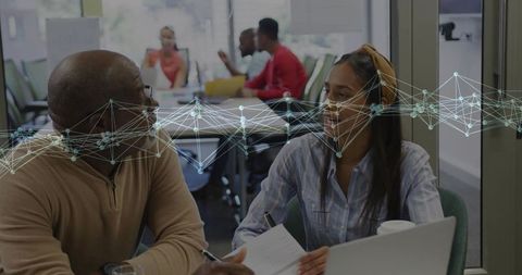 Mentoring Conversation Over Laptop and Notes in Bright Collaborative Workspace