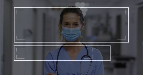 Nurse in Blue Scrubs and Mask in Hospital Corridor