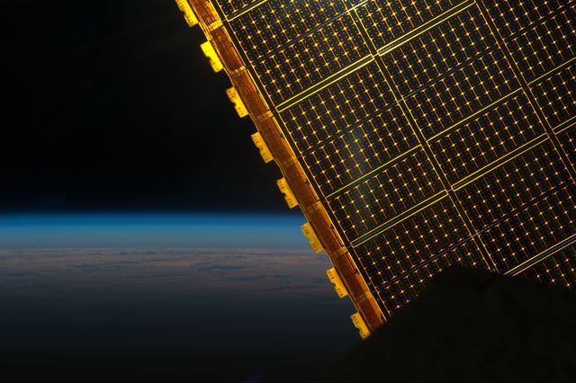 This stunning view shows the solar array panels of the International Space Station against Earth’s atmosphere and the vast blackness of space. Useful for topics on renewable energy, space exploration, technological advancements, and atmospheric studies.