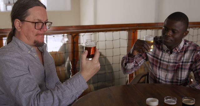 Two Men Enjoying Craft Beer at Restaurant Table - Download Free Stock Images Pikwizard.com