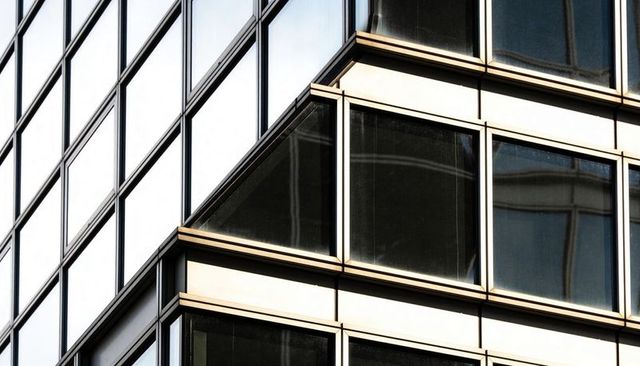 Corporate office corner featuring geometric glass curtainwall and reflective steel frames