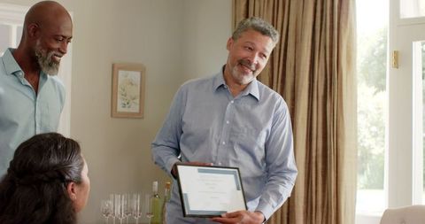 Senior man celebrates friendship at home gathering sharing award