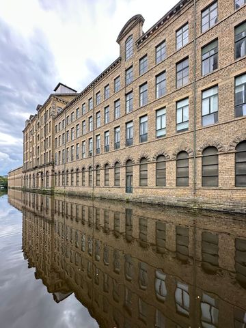 Historic industrial building with canal reflection