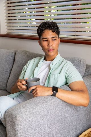 Relaxed Young Man with Coffee Mug in Modern Living Room
