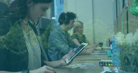 Graphic designer using tablet in modern collaborative workspace