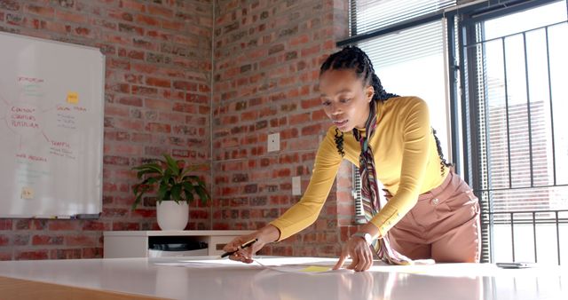 Focused Professional Woman Analyzing Documents in Modern Office - Download Free Stock Images Pikwizard.com