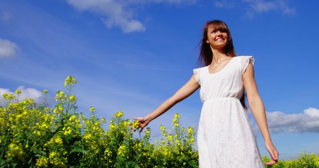 Young woman enjoying sunshine in yellow flower field - Download Free Stock Photos Pikwizard.com