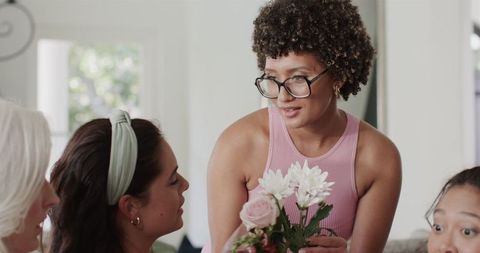 Smiling Woman with Flowers in Social Gathering at Home