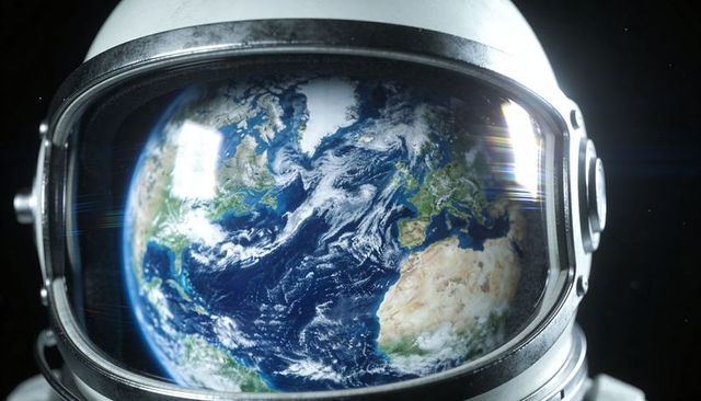 Astronaut helmet reflecting earth over atlantic ocean, visor scuffs and lens flare