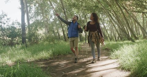 Joyful Diverse Couple Hiking in Sunlit Forest