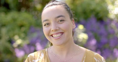 Smiling Young Woman Enjoying Sunny Garden Outdoors