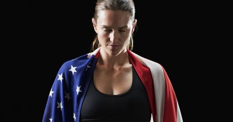 Determined athlete embracing american flag for inspiration