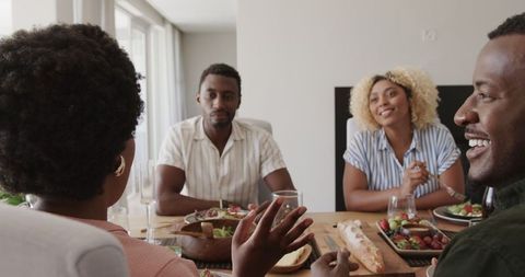 Friends sharing laughter over lunch at modern dining table