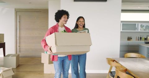 Excited Couple Moving Into New Home Holding Cardboard Box