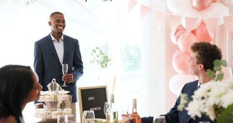 Groom giving speech with wedding guests at elegant celebration