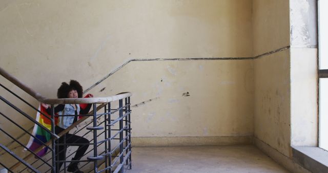 Person Sitting on Staircase with Rainbow Flag in Abandoned Building - Download Free Stock Images Pikwizard.com