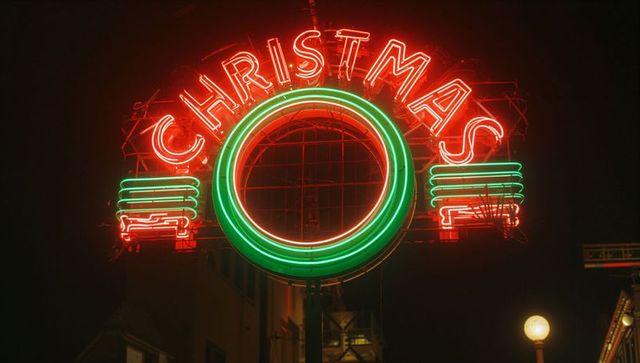 Festive neon christmas sign glowing in city night