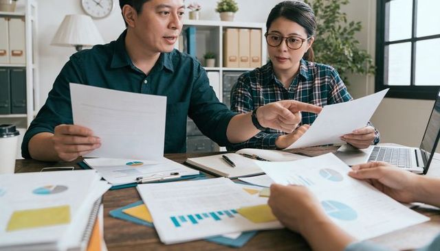 Business team reviewing financial charts and reports in collaborative office meeting