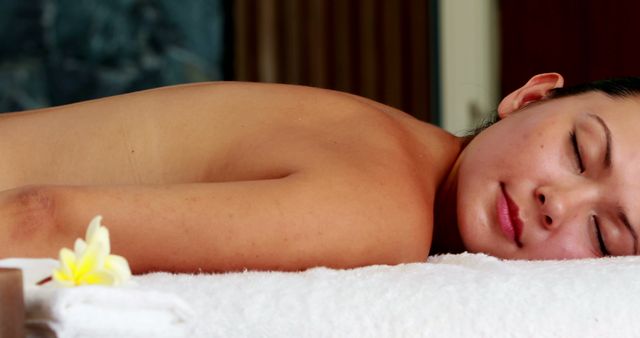 Young woman relaxing during a spa treatment provides perfect imagery for wellness and beauty promotions. Useful for concepts related to relaxation, stress relief, self-care routines, and spa services marketing. Ideal for use in advertisements, spa brochures, wellness blogs, and social media campaigns focusing on health and personal care.
