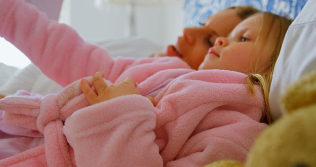 Mother and Daughter in Pink Bathrobes Relaxing Together on Bed - Download Free Stock Images Pikwizard.com