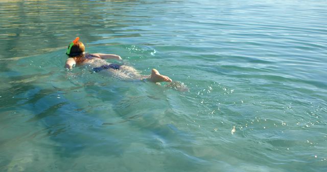Person enjoys a serene swim in clear blue waters, with copy space. Outdoor swimming provides a refreshing escape and connection with nature.
