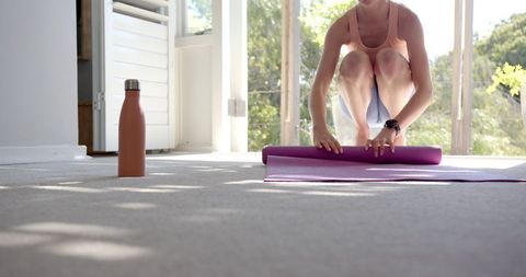 Woman Preparing Yoga Session At Home With Purple Mat