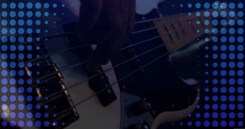 Musician playing electric bass guitar with dynamic lighting