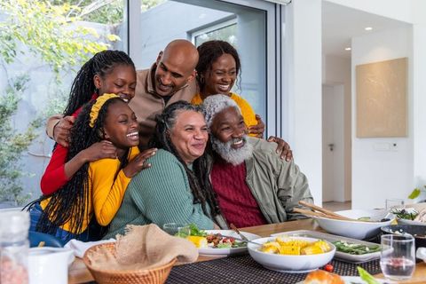 Multigenerational african american family gathering at sunlit dining table sharing joy