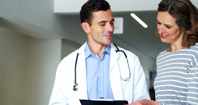 Smiling Doctor Consulting with Female Patient in Modern Clinic - Download Free Stock Images Pikwizard.com