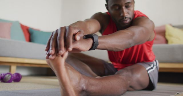 Happy african american man exercising in living room, stretching - Download Free Stock Photos Pikwizard.com