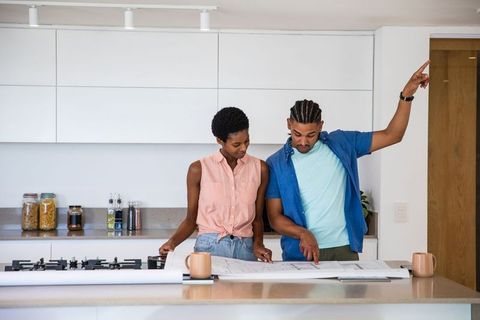 African American Couple Reviewing Home Design Plans in Modern Kitchen