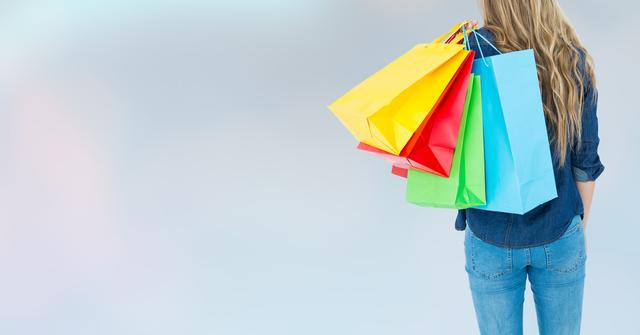Woman holding multiple colorful shopping bags against a light background. Suitable for illustrating concepts such as shopping, retail therapy, consumer habits, fashion, and lifestyle. Can be used for advertisements, blog posts, and promotional materials related to shopping, fashion sales, and holiday gifting.
