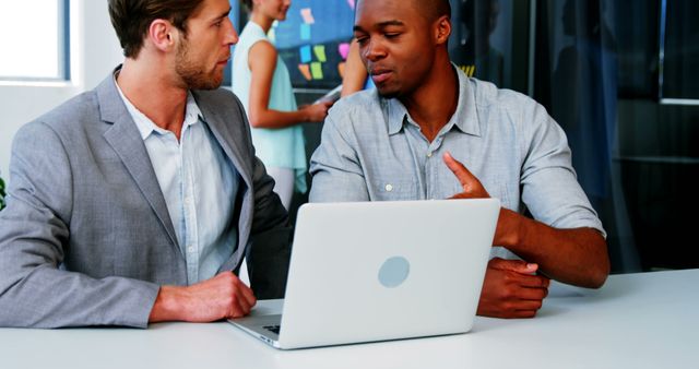 Diverse Colleagues Discussing Project on Laptop in Modern Office - Download Free Stock Images Pikwizard.com