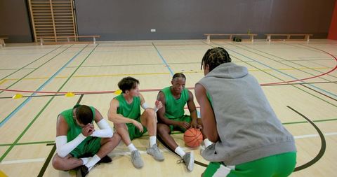Emerging african american basketball captain rallying teammates in indoor court timeout